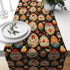 Könnte beinhalten: Ein schwarzer Tischläufer mit einem sich wiederholenden Muster aus bunten Ostereiern. Die Eier sind mit floralen Mustern verziert und haben einen volkstümlichen Stil.