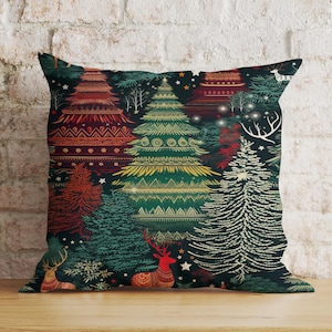Könnte beinhalten: Ein dekoratives Kissen mit dunkelgrünem Hintergrund, das ein sich wiederholendes Muster aus stilisierten Weihnachtsbäumen und Rentieren zeigt. Die Bäume sind mit geometrischen Mustern in Rot-, Grün-, Gold- und Weißtönen verziert.