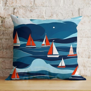 Peut inclure: Un coussin bleu et blanc avec un motif de voiliers rouges et blancs sur une mer bleue. Le coussin est fait d'un tissu doux et confortable et est parfait pour ajouter une touche nautique à n'importe quelle pièce.
