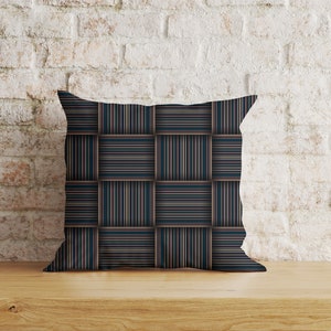 May include: A decorative pillow with a geometric pattern of dark blue, black, and white stripes. The stripes are arranged in a grid pattern, creating a woven effect.
