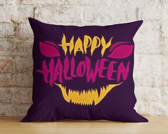 May include: Purple pillow with a yellow and pink "Happy Halloween" design. The design features a scary face with fangs.
