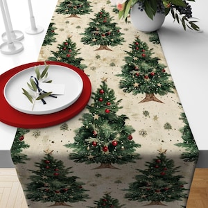 May include: A Christmas-themed table runner with a repeating pattern of decorated fir trees. The trees are green with red baubles and gold star toppers, set on a beige background with snowflakes. A red plate and white plate are on the left.