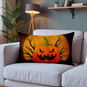 May include: Rectangular Halloween-themed pillow featuring a jack-o'-lantern with a menacing grin against a full moon backdrop. The design includes bare tree branches and grass, set against a black background. The pillow is on a white couch.