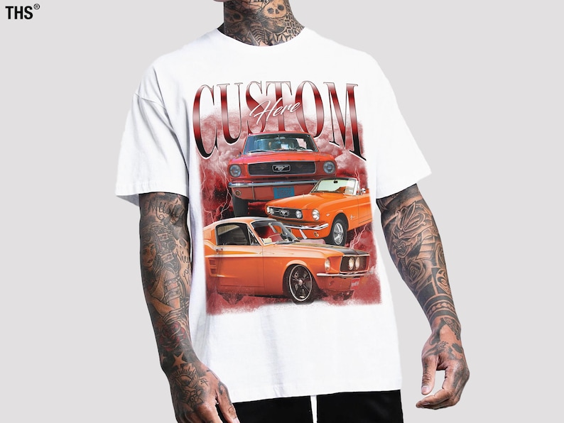 May include: White t-shirt with a graphic print of three orange and red vintage Ford Mustang cars. The text "Custom Here" is printed in red on the shirt.