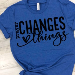 May include: A royal blue t-shirt with the text "prayer changes things" in black lettering with a heart symbol.