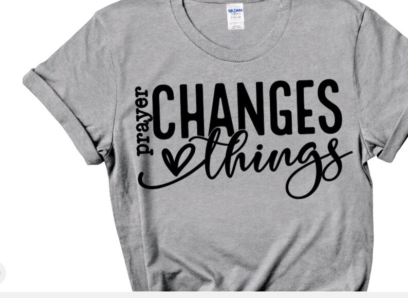 May include: Gray t-shirt with black text that reads "prayer changes things" with a heart symbol between the words.