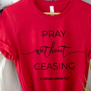 May include: Red t-shirt with black text that reads "Pray without ceasing 1 Thessalonians 5:17".