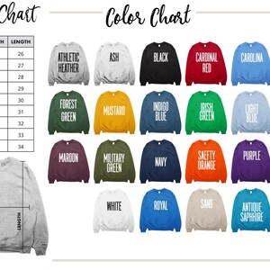 May include: Size chart for sweatshirts with width and length measurements in inches. Color chart with 20 different sweatshirt colors, including Ash, Black, Cardinal Red, Carolina Blue, Dark Heather, Forest Green, Mustard, Indigo Blue, Irish Green, Light Blue, Light Pink, Maroon, Military Green, Navy, Safety Orange, Purple, Red, White, Royal Blue, Sand, Antique Sapphire, and Safety Green.