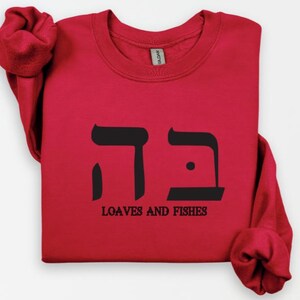 May include: Red long-sleeve sweatshirt with black Hebrew lettering and the text "Loaves and Fishes".