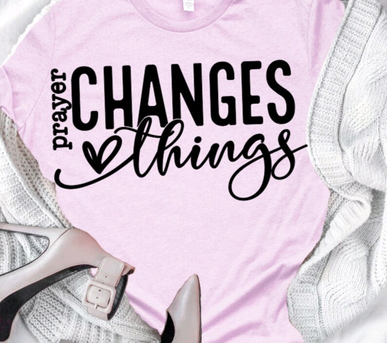 May include: Pink t-shirt with the text "prayer changes things" in black lettering with a small heart symbol.