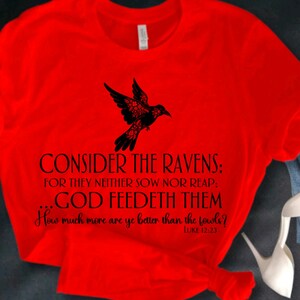 May include: Red t-shirt with a black silhouette of a bird and the text "CONSIDER THE RAVENS: FOR THEY NEITHER SOW NOR REAP: GOD FEEDETH THEM How much more are ye better than the fowls? LUKE 12:23"