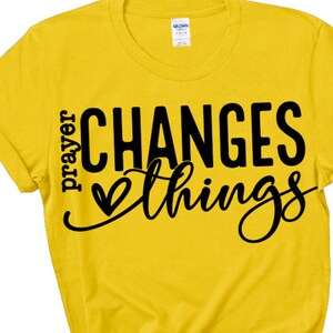 May include: Yellow t-shirt with black text that reads "prayer changes things" with a heart symbol.