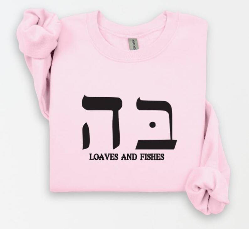 May include: Pink sweatshirt with black Hebrew lettering that says "דגים" and the words "Loaves and Fishes" underneath.