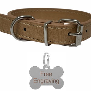 May include: Tan leather dog collar with a silver buckle and hardware. Includes a bone-shaped tag with the words "Free Engraving". The collar is stitched with a contrasting thread.