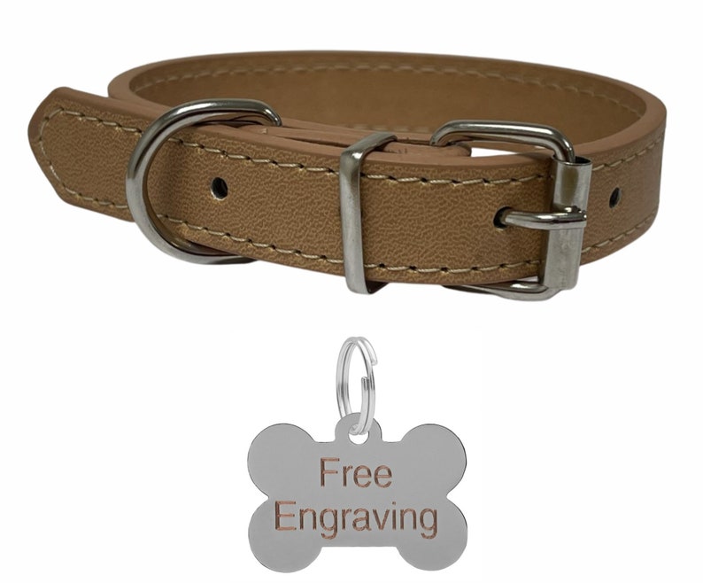 May include: Tan leather dog collar with a silver buckle and hardware. Includes a bone-shaped tag with the words "Free Engraving". The collar is stitched with a contrasting thread.