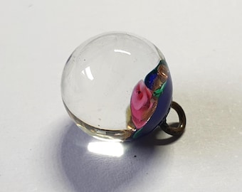 1900s ball glass paperweight button. Blue base and pink rose viewed through top clear glass. Brass loop shank. 7/16 inch wide or 11mm. PW786