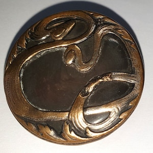 1 Art Nouveau button with white metal swirls over mother of pearl. Metal back & loop shank. Wear on a swirl. 1910. 1 7/16&quot; by 37 mm. MB325b