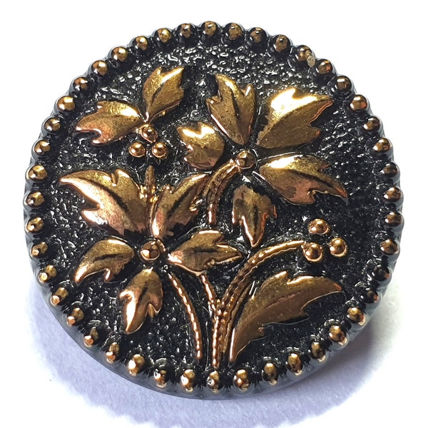 1 black glass Le Chic French button with gold lustred Poinsettias and holly leaves. Circa 1950s. Self shank. 11/16" or 18mm. GB336