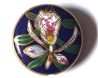 1 1880s Japanese Satsuma ceramic button. 22ct Gold. Navy background with painted Orchid. Chip to edge. Tunnel shank. 13/16" or 20mm. Sat7037