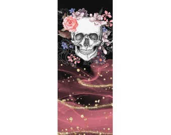 May include: A yoga mat with a pink and black marbled design. A white skull with a floral wreath is in the center of the mat.