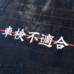 以下が含まれることがあります： 暗い濡れた表面に、赤い線が引かれた白い日本語の文字。文字は様式化されており、デカールのようです。