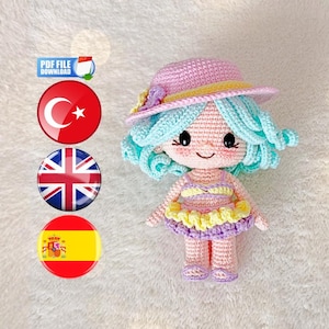 May include: A handmade crochet doll with a pink hat, blue hair, and a striped swimsuit. The doll has a yellow and purple skirt and is wearing pink shoes. The image includes a "PDF FILE DOWNLOAD" graphic and flags.