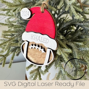 May include: A red and white Christmas bauble shaped like a football with the name "KHALED" and the year "2024" on it.