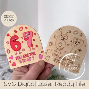May include: Two wooden laser-cut designs featuring the numbers 6 and 7, each with a face, hearts, and the text "YOU ARE THE 6 TO MY 7". One is red and pink, the other is uncoloured. The design includes stars and hearts.