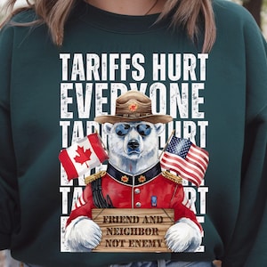 May include: A green sweatshirt featuring a white graphic of a polar bear dressed as a Canadian Mountie, wearing sunglasses and holding a sign that reads "Friend and Neighbour Not Enemy". The design also includes Canadian and American flags.