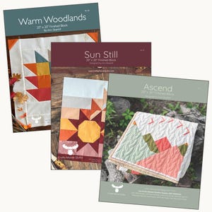 May include: Four quilt pattern covers are displayed, featuring colorful geometric designs. The covers include the titles "Warm Woodlands," "Sun Still," and "Ascend." Each pattern is for a 20" x 20" finished block, designed by Ann Skathill.