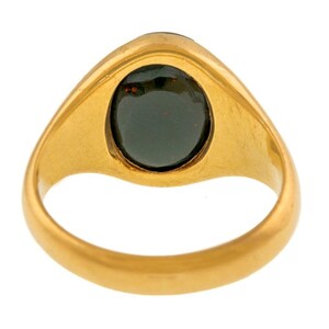 K&ouml;nnte beinhalten: Ein goldener Ring mit einem dunklen, oval geformten Stein. Der Ring hat ein glattes, poliertes Band und eine Fassung, die den Stein sicher h&auml;lt. Der Stein scheint eine tiefe, m&ouml;glicherweise dunkelgr&uuml;ne oder schwarze Farbe zu haben.