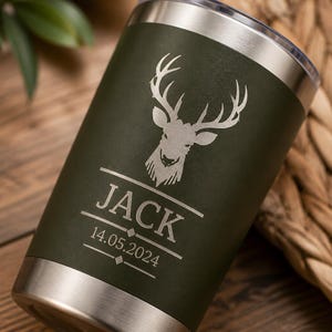 Könnte beinhalten: Ein dunkelolivgrüner Edelstahlbecher mit einer lasergravierten Hirschkopf-Grafik über dem Namen JACK und dem Datum 14.05.2024, getrennt durch horizontale Linien und kleine Rautenakzente, mit einem silberfarbenen Rand und Boden.