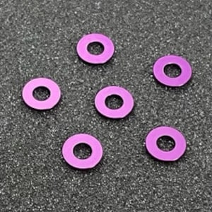 Puede incluir: Seis arandelas de metal de color púrpura. Las arandelas son redondas con un agujero en el centro.