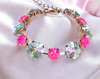 May include: A rose gold tone bracelet featuring alternating round faceted crystals in vibrant neon pink and iridescent clear white. The bracelet includes a metal chain link extension and a lobster claw clasp, with each stone securely held in a prong setting.
