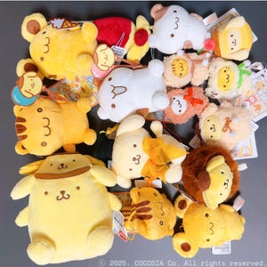 Peut inclure: Une collection de peluches en forme d'animaux variés, dont des ours, des tigres et des lions. Les jouets sont principalement jaunes, oranges et blancs, avec des détails brodés et le chiffre "3" sur chacun. Certains ont des accessoires.