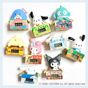 May include: A collection of colorful character-themed digital clocks. Each clock features a different cartoon character and is set inside a small, box-shaped display. The clocks display the time in a digital format.