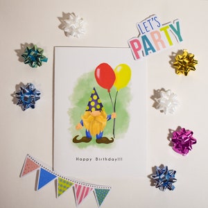 May include: A birthday card with a cartoon gnome holding balloons. The card has a green watercolor background and the text "Happy Birthday!!" The card is surrounded by colorful bows.