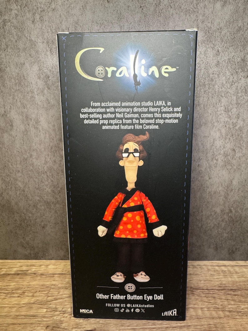 May include: A box featuring the Coraline movie logo and a doll of the Other Father character. The doll wears a red jacket with orange polka dots, black pants, and white shoes. The box includes text about the film and the doll's origin.