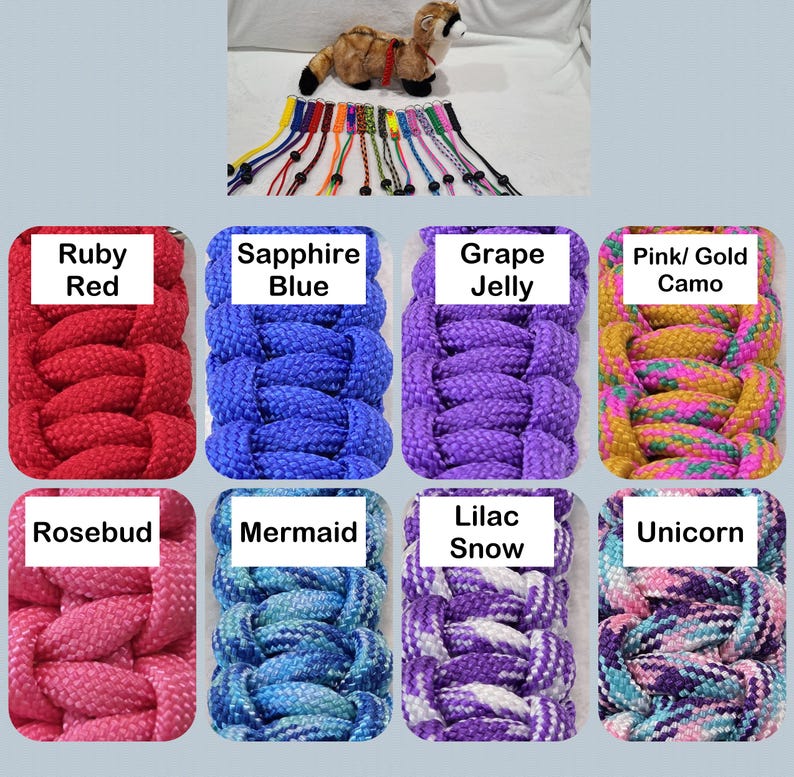 May include: A variety of colorful braided dog collars are displayed, each labeled with a unique color name. Colors include Ruby Red, Sapphire Blue, Grape Jelly, Pink/Gold Camo, Rosebud, Mermaid, Lilac Snow, and Unicorn. A stuffed animal is also present.