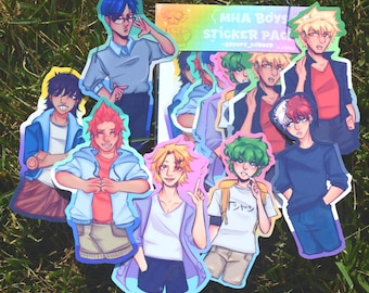 Könnte beinhalten: Eine Sammlung von Aufklebern im Anime-Stil mit verschiedenen männlichen Charakteren. Die Aufkleber sind farbenfroh und haben einen weißen Rand. Der Text "MHA Boys Sticker Pack" ist auf einem rechteckigen Aufkleber zu sehen. Die Aufkleber sind auf grünem Gras angeordnet.