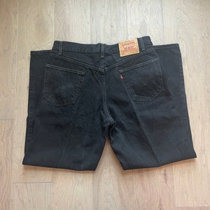 May include: Black denim jeans with a Levi's label on the back pocket.