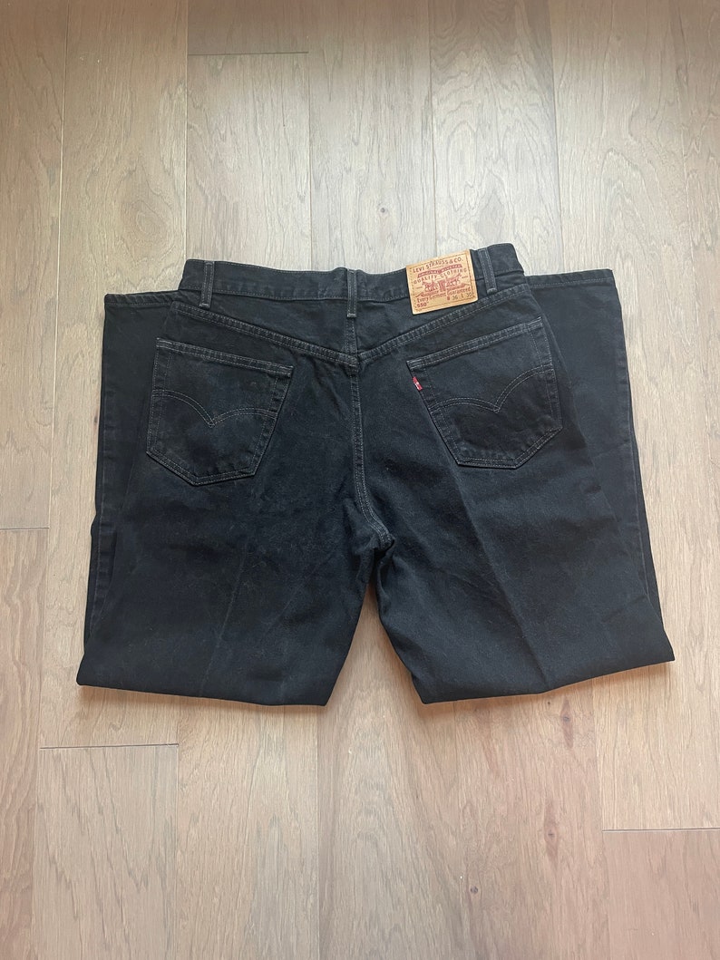 May include: Black denim jeans with a Levi's label on the back pocket.