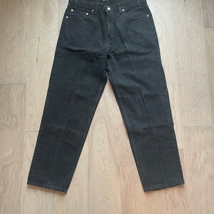 May include: Black denim jeans with a straight leg fit.