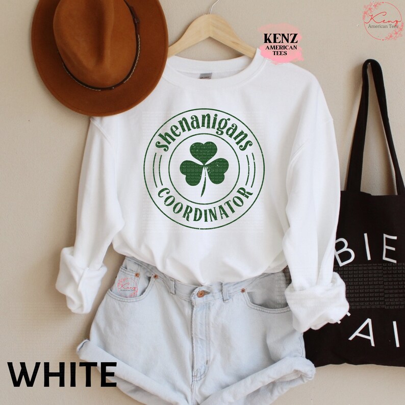 May include: White sweatshirt with a green shamrock and the text "Shenanigans Coordinator" in a circle.
