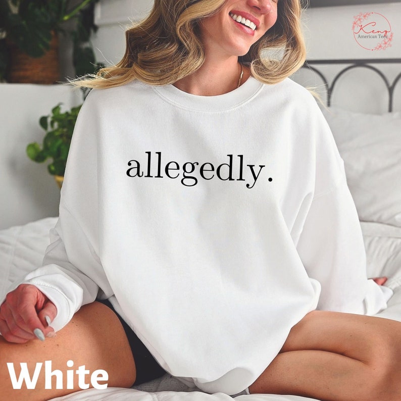 May include: White sweatshirt with the word "allegedly" printed in black. The sweatshirt is a crew neck style. The word "White" is printed at the bottom of the image.