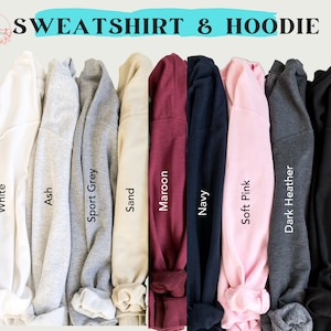 Puede incluir: Una selecci&oacute;n de sudaderas y sudaderas con capucha en varios colores, incluyendo blanco, ceniza, gris deportivo, arena, granate, azul marino, rosa suave, gris oscuro jaspeado y negro. El texto "SWEATSHIRT & HOODIE" se muestra en la parte superior de la imagen.