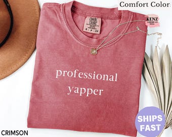 May include: Crimson red t-shirt with the text "professional yapper" printed in white.
