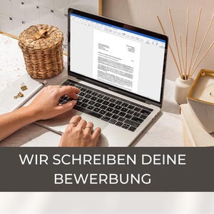 Könnte beinhalten: Eine Person tippt auf einem Laptop mit einem leeren Dokument, das geöffnet ist. Der Laptop steht auf einer weißen Oberfläche mit einem Weidenkorb, einer Kerze und einem Kalender im Hintergrund. Der Text auf dem Bildschirm lautet "Wir schreiben deine Bewerbung", was "Wir schreiben Ihre Bewerbung" bedeutet.