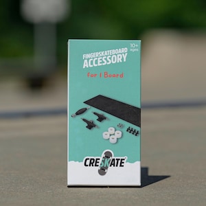 Puede incluir: Una caja azul turquesa con el texto "FINGERBOARD ACCESSORY for 1 Board" y el texto "CRESKATE" en blanco. La caja contiene una tabla de dedos negra, camiones negros, ruedas blancas y tornillos negros.