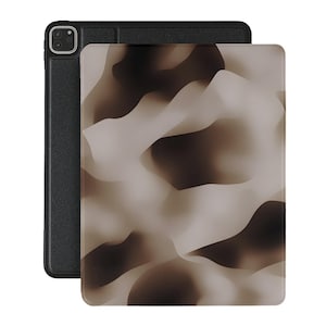 Op de afbeelding: Een zwarte leren iPad-hoes met een bruin en wit abstract patroon op de achterkant.